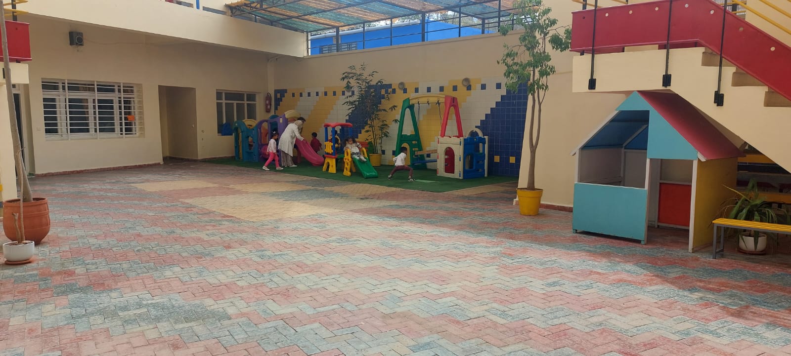 Cour de récréation dédiée à la maternelle avec structures de jeux