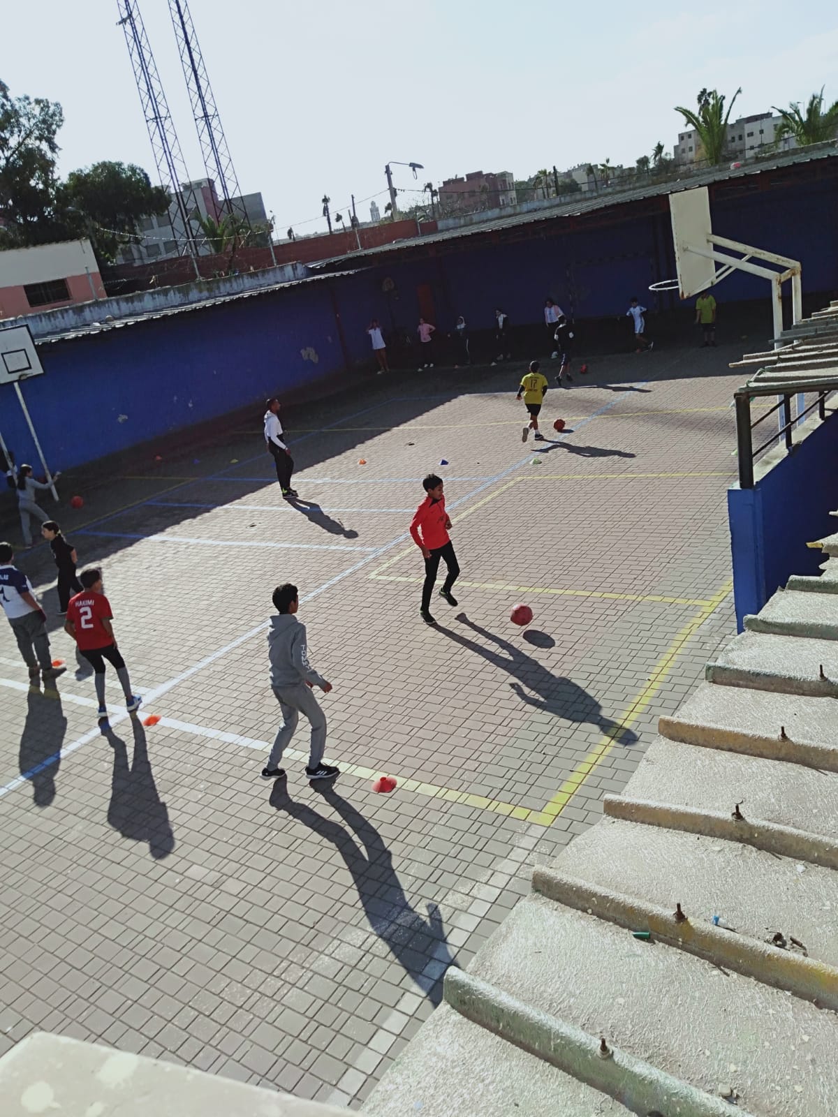 Collégiens en séance de football encadrée sur le terrain de sport