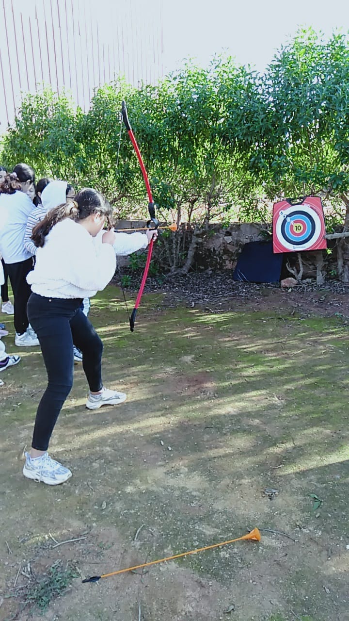 Collégienne s'entraînant au tir à l'arc lors d'une sortie pédagogique