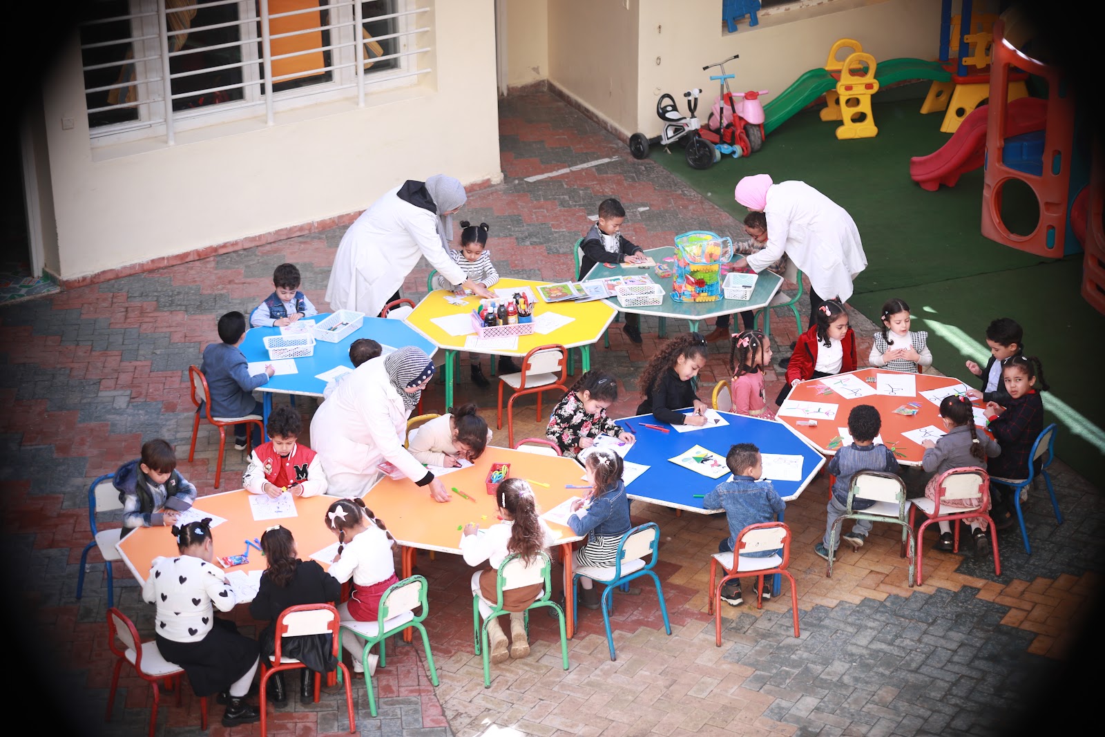 Ateliers de maternelle encadrés par les enseignantes dans la cour