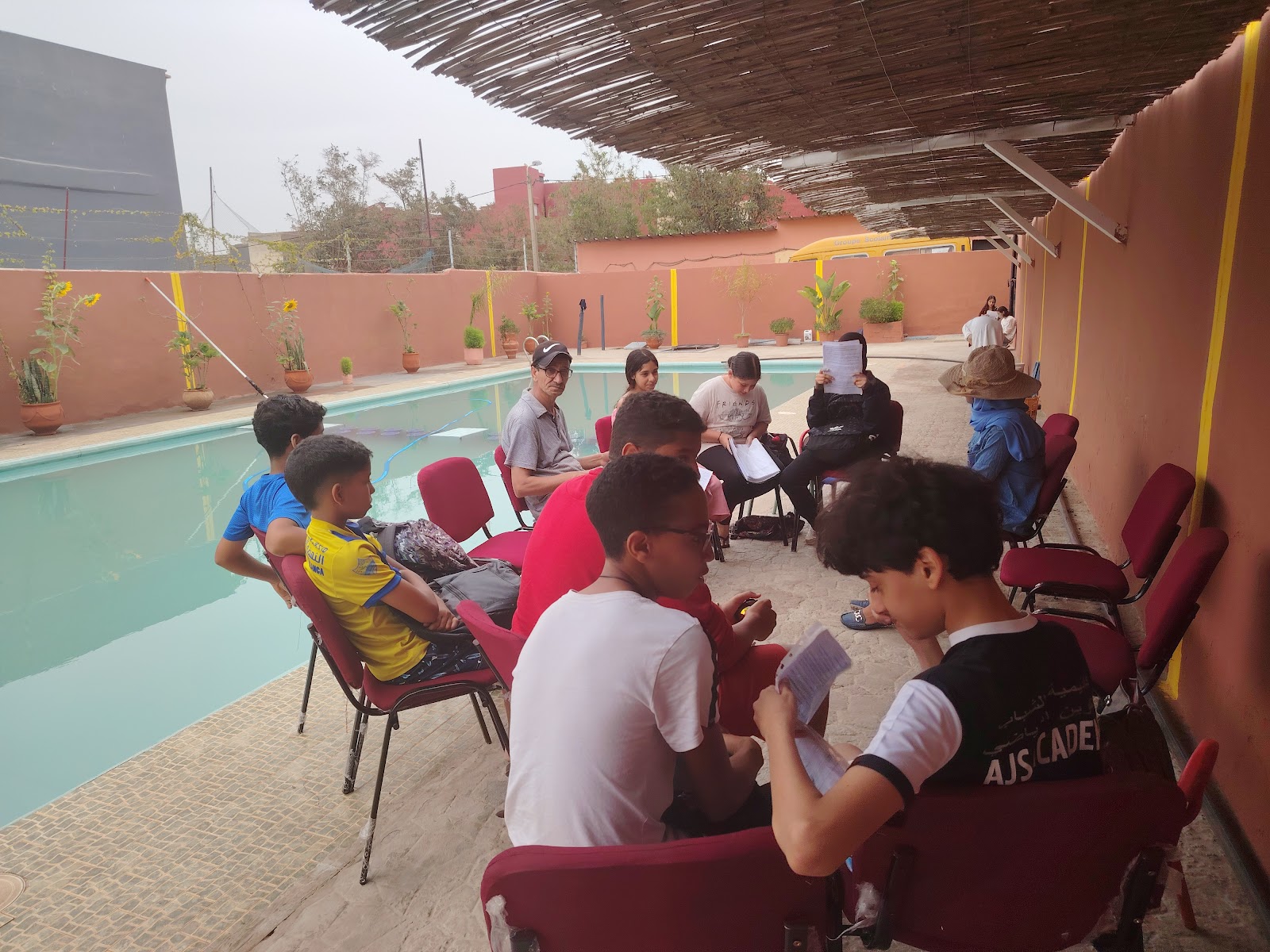 Élèves du lycée privé travaillant en plein air au bord de la piscine, Sidi Maârouf